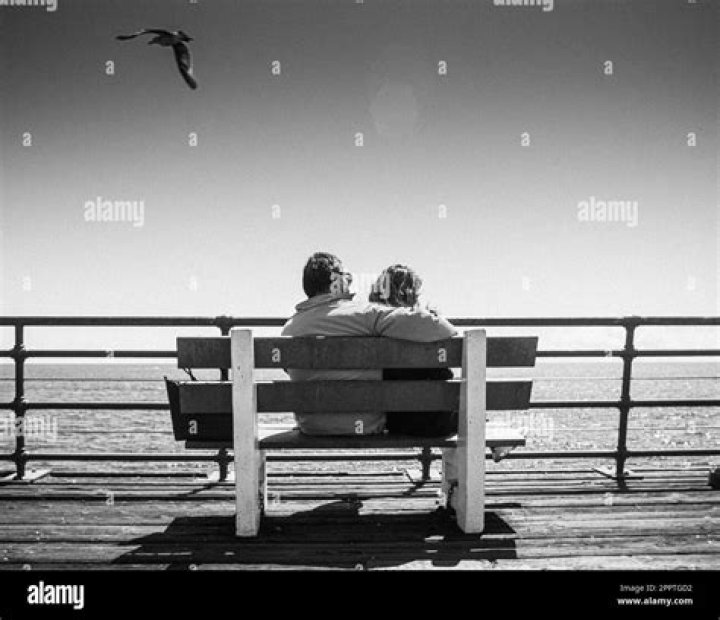a man and woman sitting at a table with wine glasses