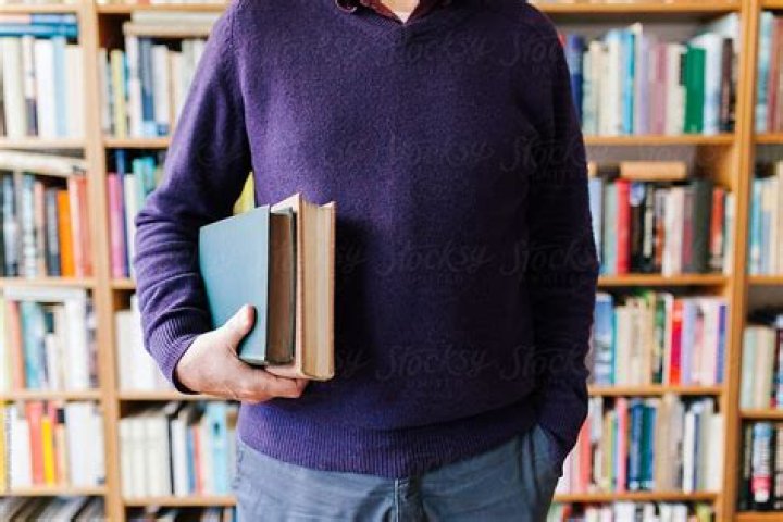 a man holding a book in his right hand