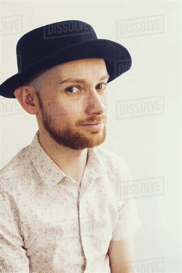 a man wearing a hat and scarf talking to someone