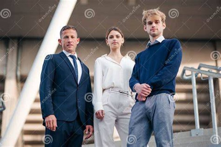 three people standing next to each other in front of a white door with